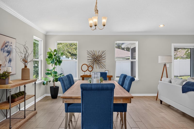 Dining room with wood table and large windows at 10066 Andean Fox Dr, Jacksonville, FL 32222