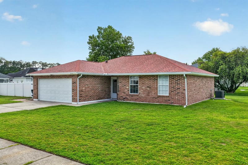 Front exterior with brick facade and red tile roof at 2164 Orangewood St, Middleburg, FL 32068