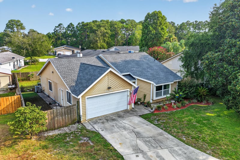 Side exterior view with driveway and fenced yard at 13020 Medford Ln, Jacksonville, FL 32225
