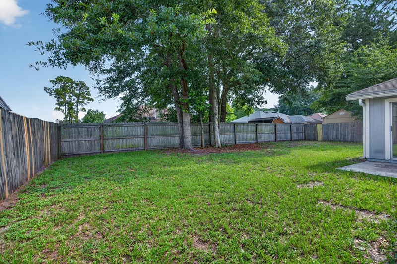Backyard corner with trees and fence at 8519 Blazing Star Ct, Jacksonville, FL 32210