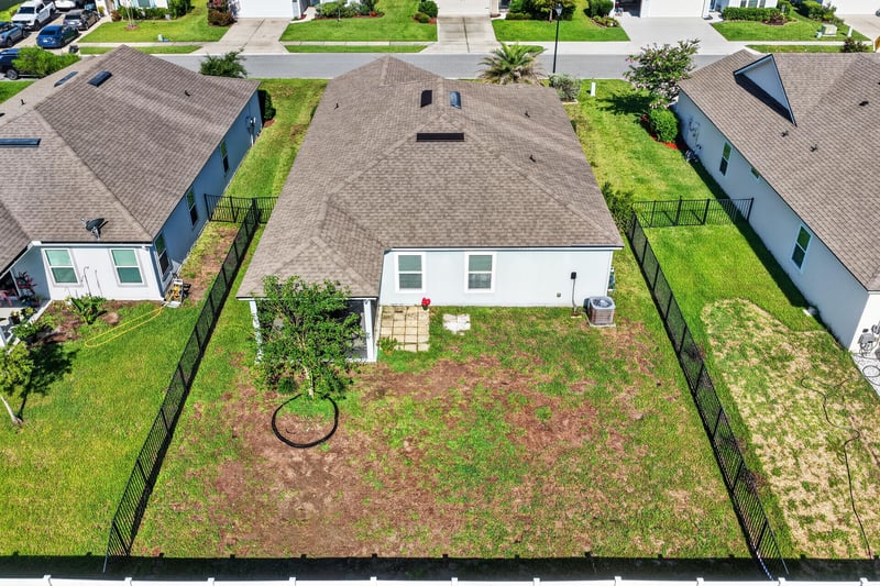 Aerial view of fenced backyard and neighborhood at 589 Seville Pkwy, St. Augustine, FL