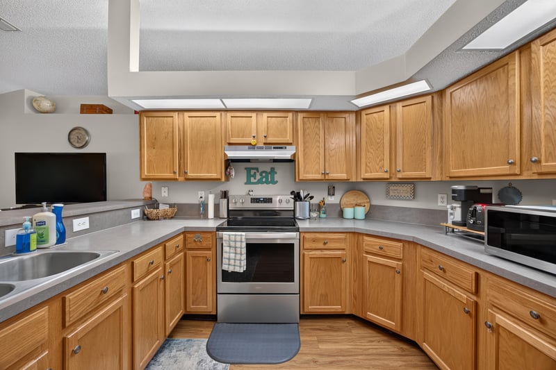 Kitchen with oak cabinets, stove and pendant lighting at 13514 Las Brisas Way N, Jacksonville, FL