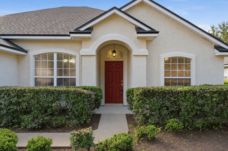 Front entry with arched window and red door at 14187 Big Spring St, Jacksonville, FL 32258