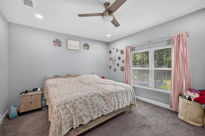 Bedroom with pink curtains and natural light at 2817 Camel Cir, Middleburg, FL