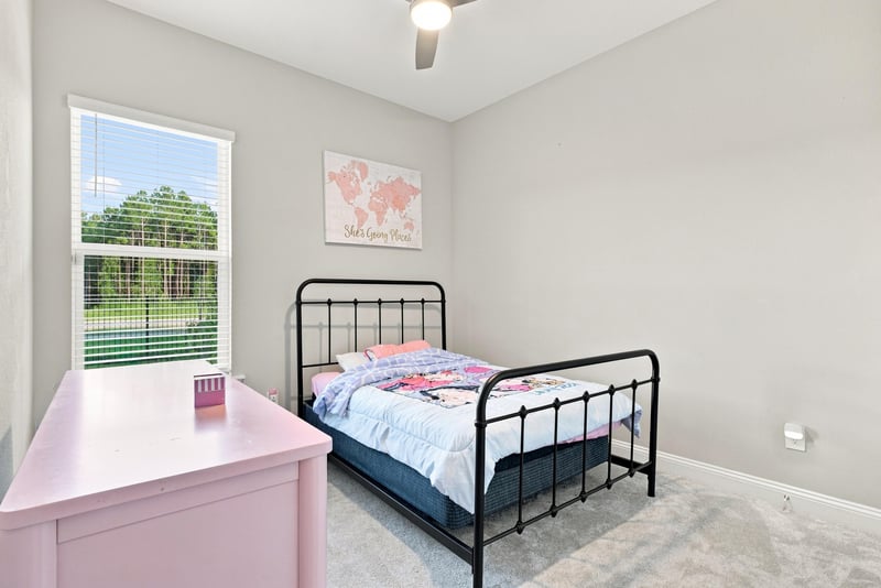 Bedroom with pink dresser and metal bed frame at 27 Holly Rdg Wy, St. Augustine, FL