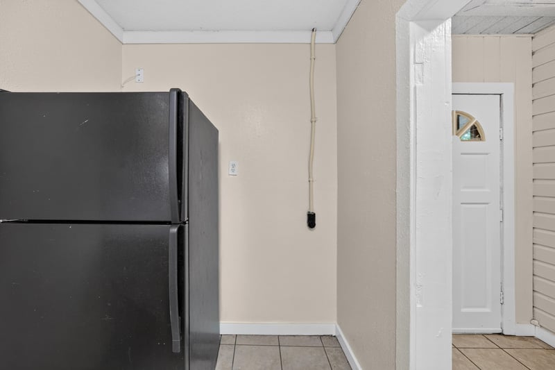 Kitchen with black refrigerator and tile flooring at 1473 State St W, Jacksonville, FL 32209