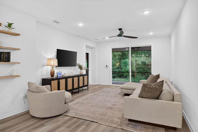 Living room with sectional and wall-mounted TV at 93 Lochloosa Ct, St. Johns, FL 32259
