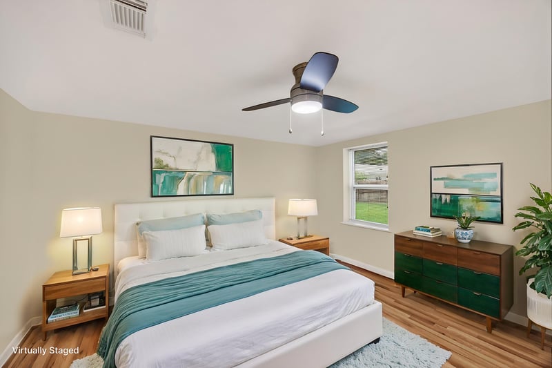 Staged bedroom with teal accents and wood dresser at 1619 Hammond Blvd, Jacksonville, FL