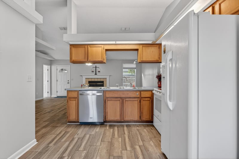 Kitchen with white appliances and wood cabinets at 2164 Orangewood St, Middleburg, FL 32068