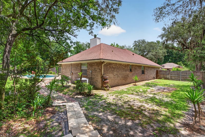 Backyard pathway with brick home exterior at 12810 Swamp Owl Ln
