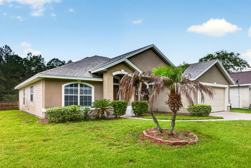 Front exterior with palm tree and landscaped lawn at 706 Bonaparte Dr, Jacksonville, FL 32218