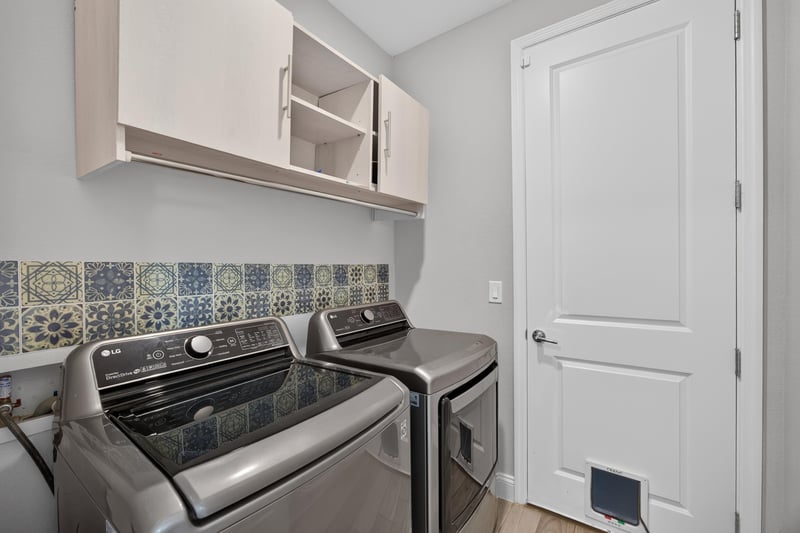Laundry room with washer, dryer and upper cabinets at 91 Tilloo Ct, St. Johns, FL