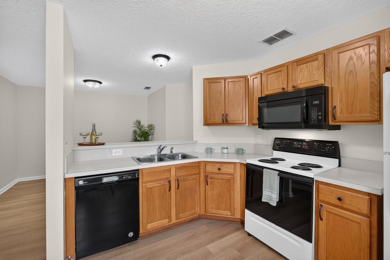 Kitchen with oak cabinets and black appliances at 605 N Covered Bridge Rd, Jacksonville, FL