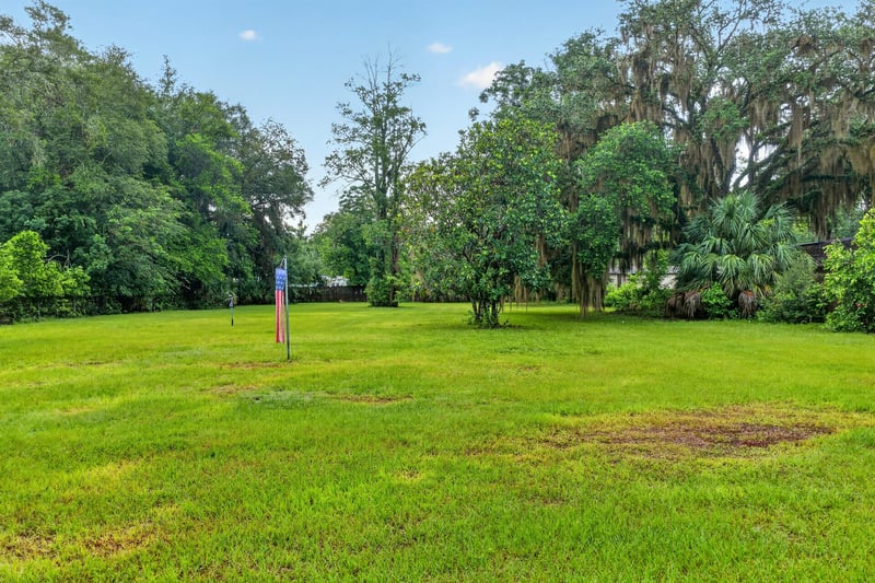 Open grass yard bordered by trees at 1619 Hammond Blvd, Jacksonville, FL