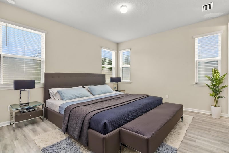 Staged primary bedroom with upholstered bed at 7088 Mahogany Run Dr, Jacksonville, FL 32244