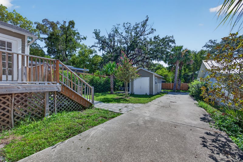 Rear exterior with wood stairs, driveway and storage shed at 1555 Belmonte Ave, Jacksonville, FL 32207