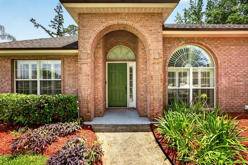 Front entry with arched doorway and brick detail at 1955 GUARDED Way, Fleming Island, FL 32003