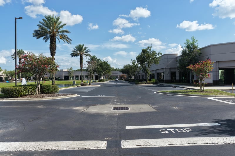 Parking lot with palm trees and stop sign at 10550 Deerwood Park Blvd, Jacksonville, FL 32256