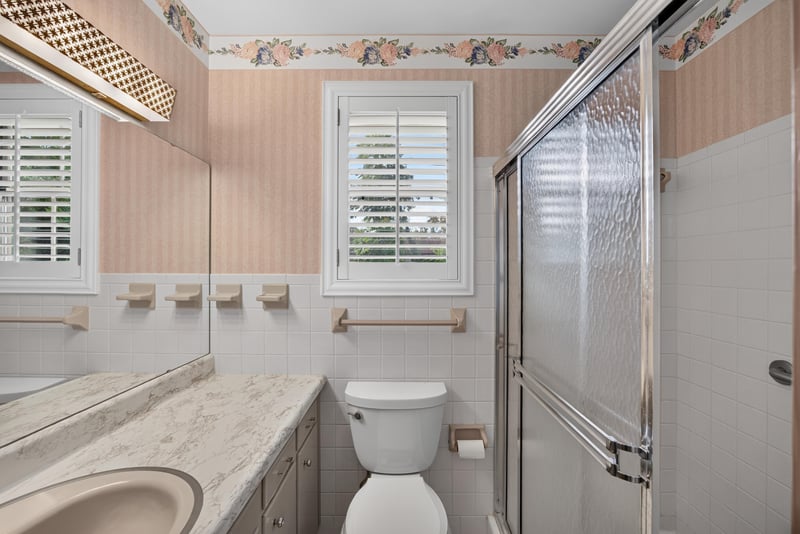 Bathroom vanity and mirror with floral wallpaper border at 1834 Memory Ln, Jacksonville, FL