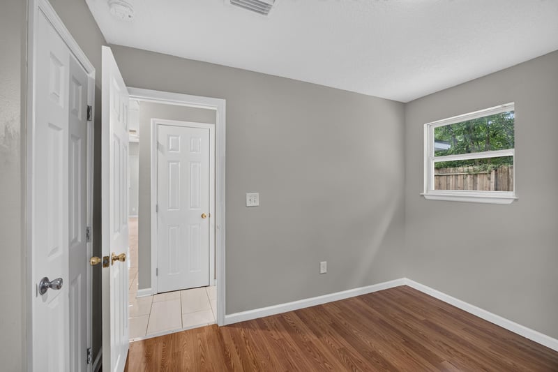 Hallway with door and wood floor at 7015 Miss Muffet Ln N, Jacksonville, FL 32210