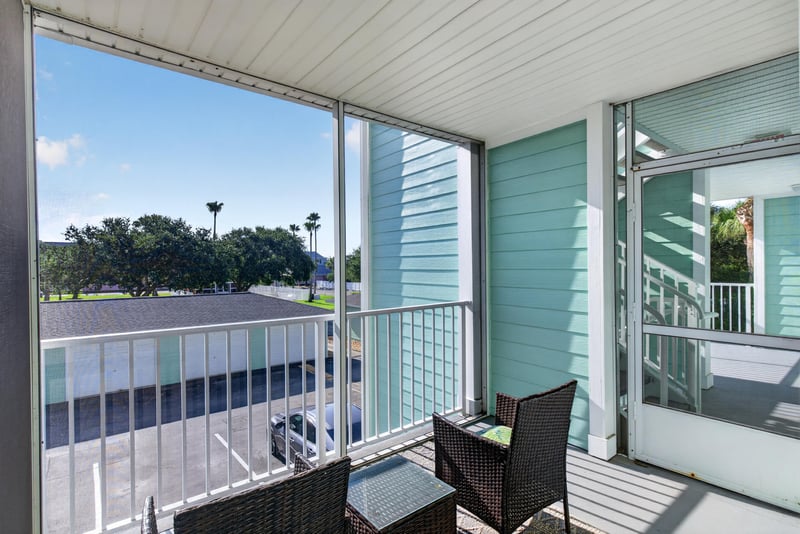 Screened porch with seating overlooking the parking lot at 206 16th St, St. Augustine, FL 32080