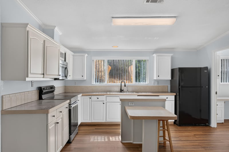 Kitchen with white cabinets and black appliances at 3215 Robin Ln, Middleburg, FL