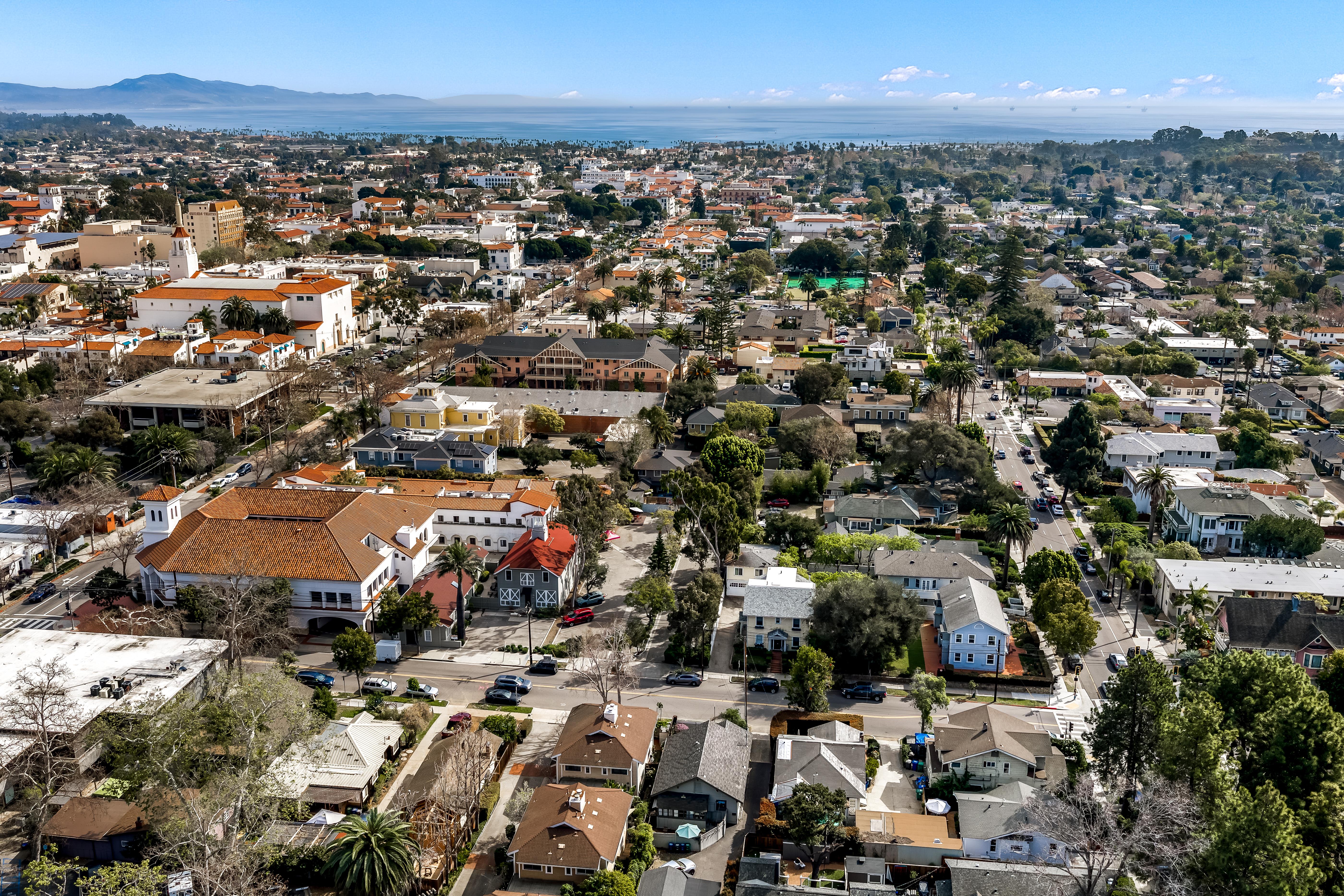Real estate drone photography of 1508 De La Vina St, Santa Barbara — rooftop and streetscape perspective near the American Riviera