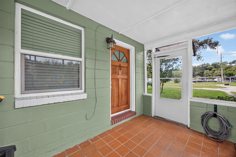 Screened front porch, wood door and tile floor at 2256 Inwood Cir S, Jacksonville, FL