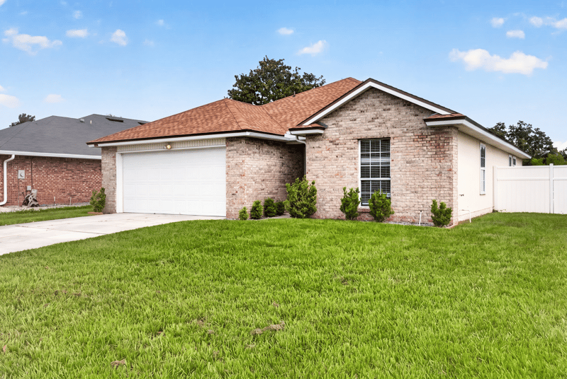 Side angle of brick front exterior and landscaping at 490 Hillside Dr, Orange Park, FL 32073