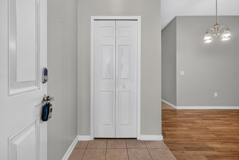 Entry foyer with coat closet and wood-look flooring at 8196 Cabin Lake Cir, Jacksonville, FL 32256