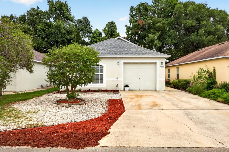 Front exterior with driveway and landscaped bed at 7329 Lawn Tennis Ln, Jacksonville, FL