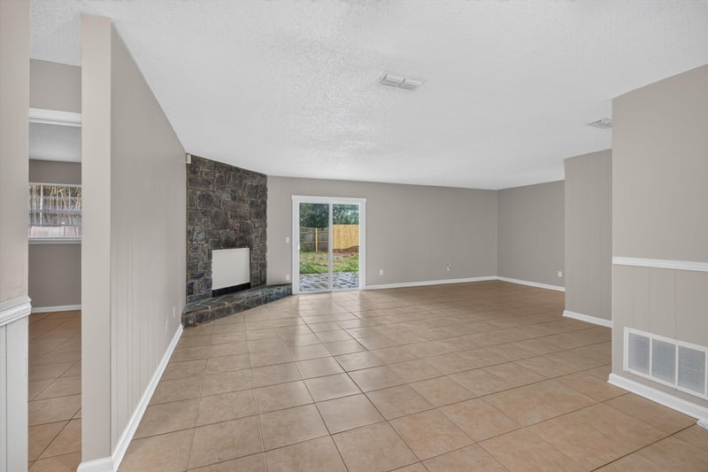 Living room with stone accent wall and sliding door at 1040 Willow Cove Ct E, Jacksonville, FL 32233