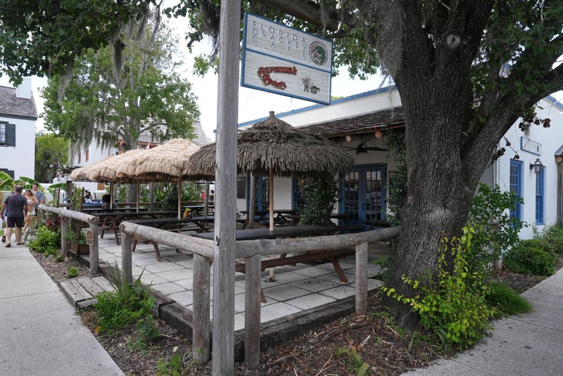 Shaded patio with a tiki-roofed seating area beneath an oak tree at 29 Cuna St, St. Augustine, FL 32084