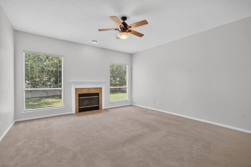 Living room with fireplace and large windows at 2480 Ridge Will Dr, Jacksonville, FL 32246