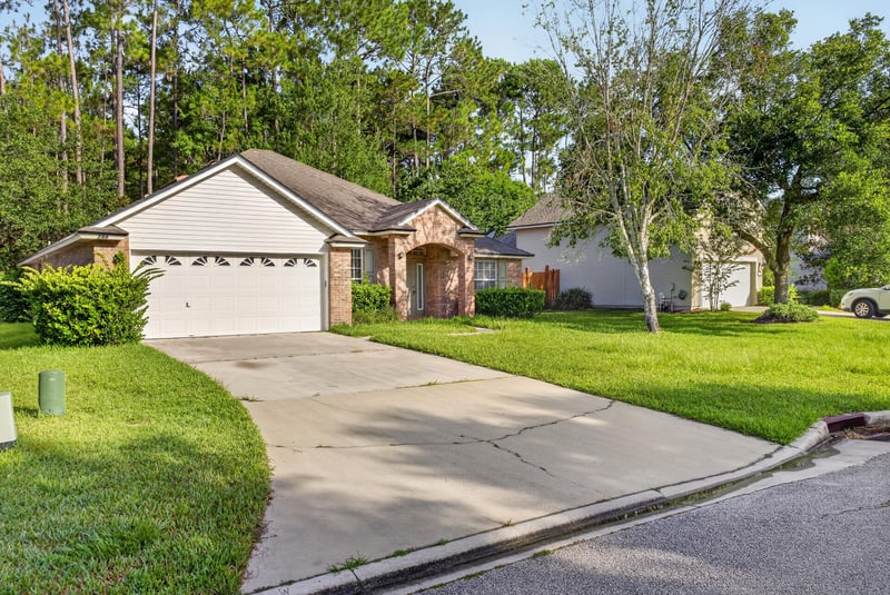 Front exterior and driveway with manicured lawn at 299 John's Creek Pkwy, St. Augustine, FL 32092