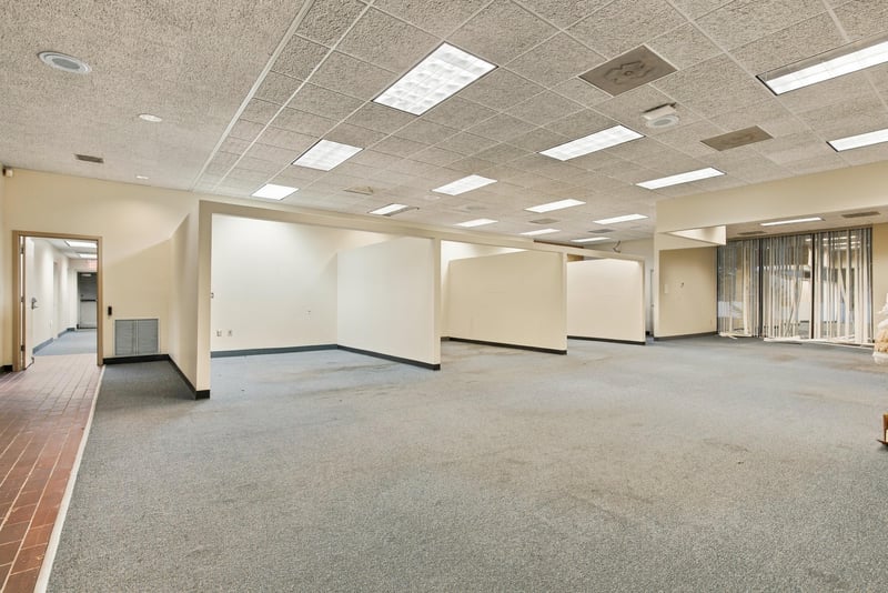 Open carpeted office space with suspended ceiling at 101 Scholars Wy