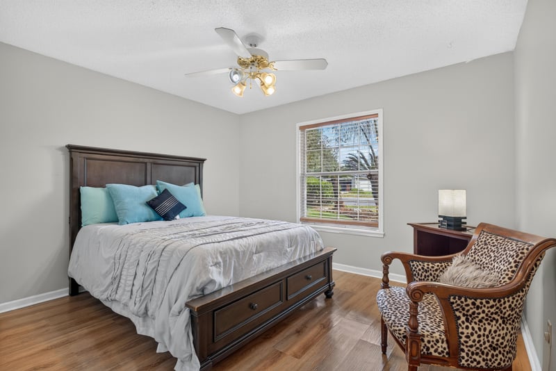 Bedroom with bed and accent chair at 8680 Bandera Cir S, Jacksonville, FL 32244