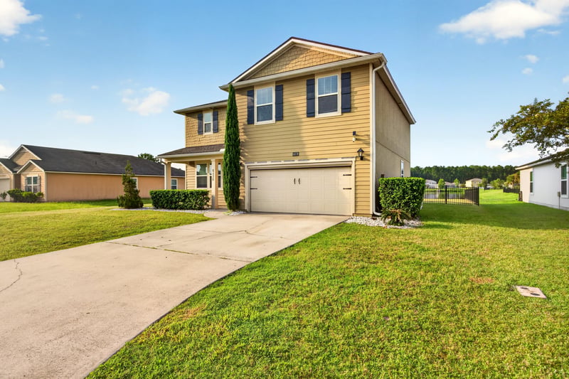 Front exterior across the lawn with two-car garage at 6830 Hanford St, Jacksonville, FL 32219