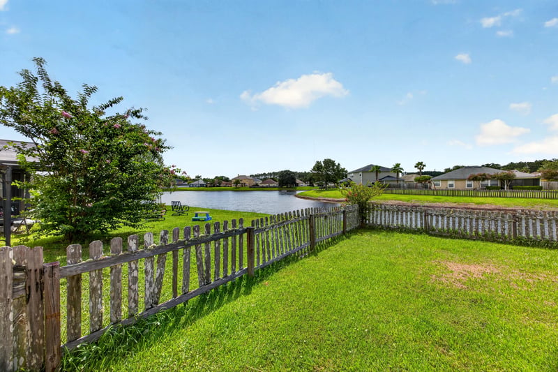 Backyard with pond view beyond the fence at 2065 Creekmont Dr
