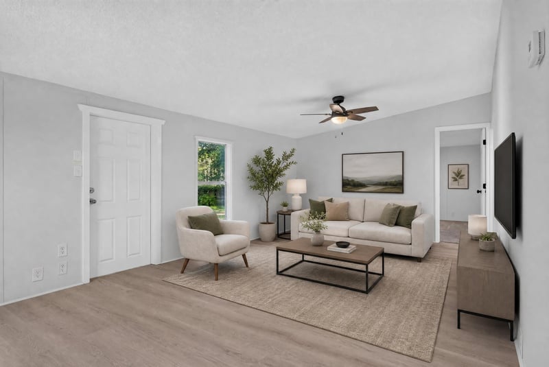 Virtually staged living room with sofa and television at 55520 Jewel-Thomas Rd, Callahan, FL 32011