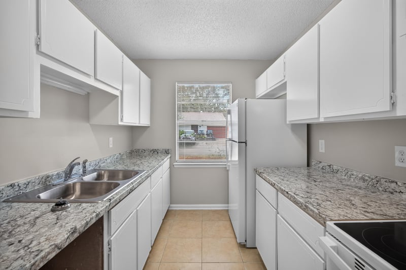 Kitchen with white cabinets and granite counters at 1040 Willow Cove Ct E, Jacksonville, FL 32233