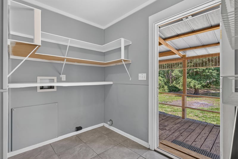 Laundry room with door open to covered deck at 2549 Snapdragon Ave, Middleburg, FL 32068