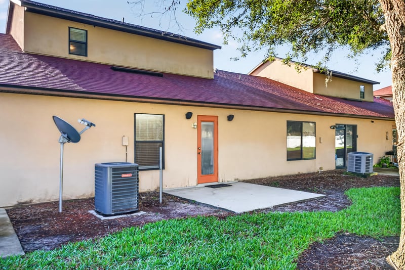 Rear patio area with AC units and grass at 353 Redwood Ln