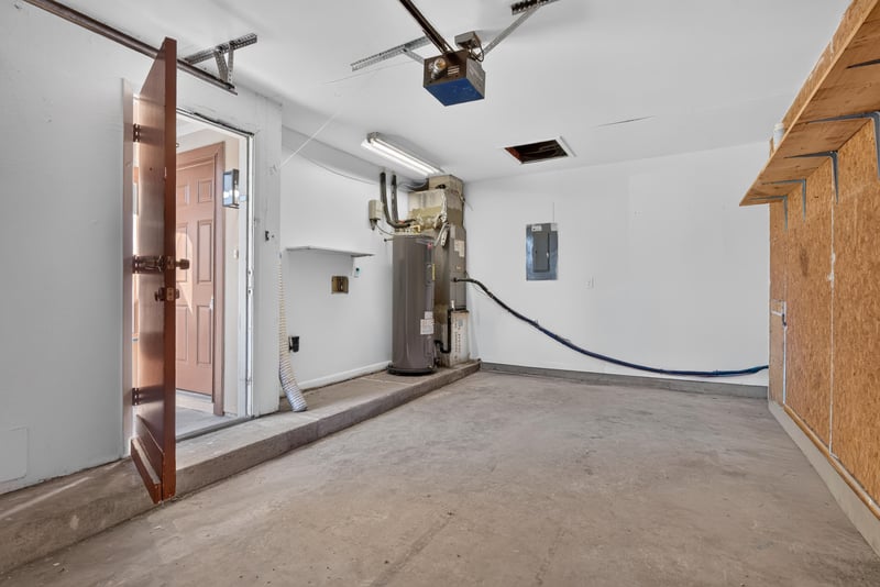Garage interior with ceiling fan and red door at 8177 Virgo St, Jacksonville, FL 32216