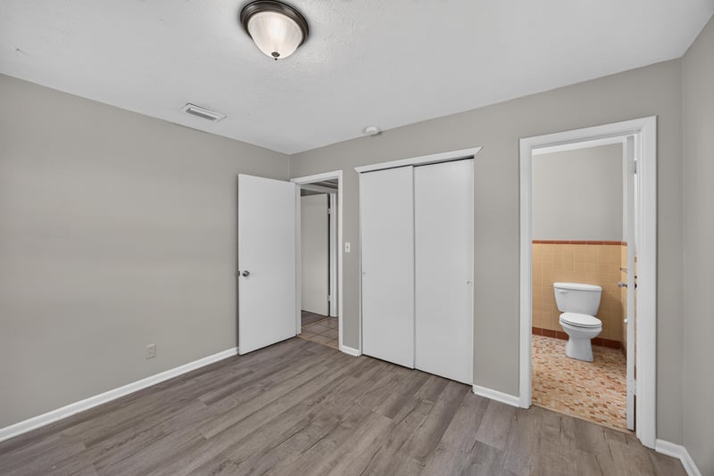 Bedroom with wood-look flooring and bathroom doorway at 5527 Beney Rd, Jacksonville, FL 32207