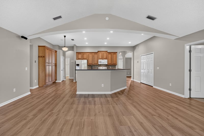 Open kitchen and living area with wood floors at 1955 GUARDED Way, Fleming Island, FL 32003