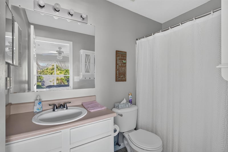 Bathroom with sink, mirror and shower curtain at 206 16th St, St. Augustine, FL 32080