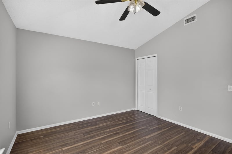 Bedroom with wood-look flooring and closet door at 7329 Lawn Tennis Ln, Jacksonville, FL