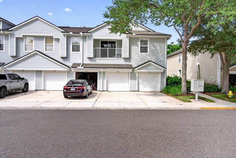 Front exterior with driveway and parked cars at 7047 Deer Lodge Cir, Jacksonville