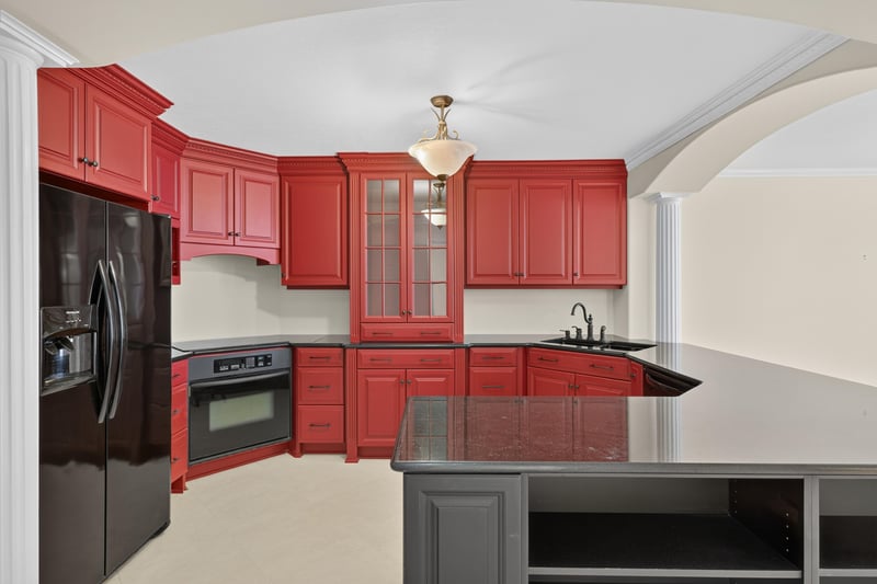Kitchen with red cabinets and black appliances at 1301 1st St S